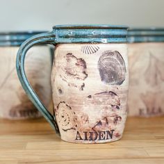 two ceramic mugs sitting on top of a wooden table