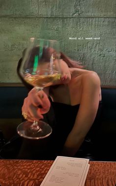 a woman holding a wine glass up to her face