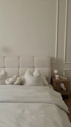 a bed with white sheets and pillows on it