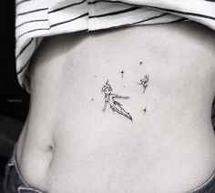 a woman's stomach with a small tattoo on her lower back and an arrow in the middle