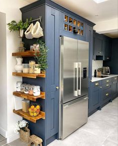 a kitchen with blue painted cabinets and shelves