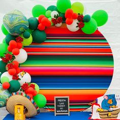 there is a colorful display with balloons and decorations on the table in front of it