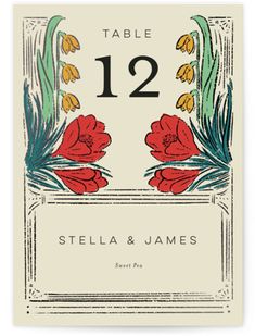 a table number card with red flowers and green leaves on the front, reads 12 stella & james