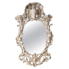 an ornate white mirror with a woman's face on it