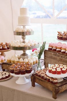 a table topped with lots of cupcakes and cakes