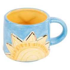 a blue and yellow ceramic mug with the sun on it