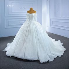 a white wedding dress on display in a room