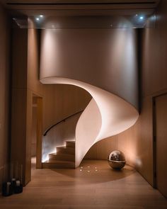 a spiral staircase in a modern home with wood paneling and white paint on the walls