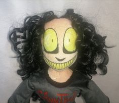 a creepy doll with black hair and green eyes