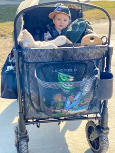 a small child in a stroller with stuffed animals on it's back,