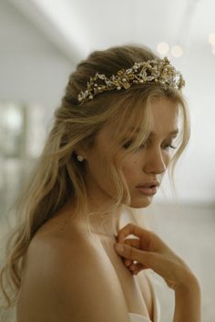 a woman in a white dress wearing a gold headpiece