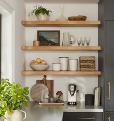 the shelves in this kitchen are filled with dishes, cups and utensil holders