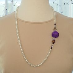 White pearl necklace with a purple mesh ball surrounded by Chinese crystal rondelle; Chinese teardrop in iridescent purple; a smaller Chinese crystal rondelle; Czech round in purple metallic; and finished with a soft purple pearl rice-shaped bead. The pearls are 6mm rounds; the mesh ball is 24mm; the rondelle beads are 8x12mm; the teardrop beads are 14x8mm; the smaller rondelles are 4x6mm; the rounds are 6mm and the final rice-shaped beads are 4x6mm. The necklace length is 29".  Lobster clasp, rings and crimps in sterling silver. N0026 Purple Pearl Single Strand Jewelry, Purple Single Strand Pearl Jewelry, Elegant Purple Spacer Beads, Purple Pearl Single Strand Necklace, Purple Single Strand Pearl Necklace, Elegant Purple Necklace With Large Beads, Elegant Purple Beads For Party, Elegant Large Purple Beads, Adjustable Purple Pearl Necklace With Round Beads