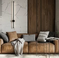 a living room with a brown couch and some pillows on the floor next to a table