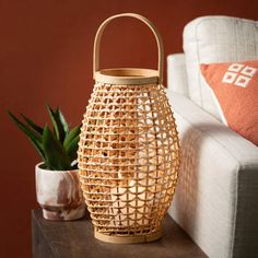 a basket sitting on top of a wooden table next to a potted succulent