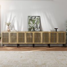 a living room with white walls and wooden furniture in the center, along with potted plants