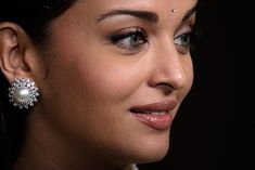 a close up of a person wearing some kind of earring with pearls on it