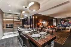 a dining room table with place settings in front of an open kitchen and living area