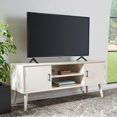 an entertainment center with a large flat screen tv mounted on it's sideboard