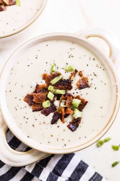 two white bowls filled with soup and bacon