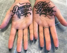 two hands that have tattoos on them