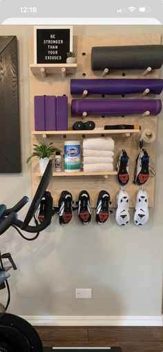 there is a wall mounted exercise bike rack in the room with many items on it