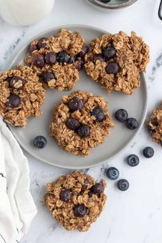 blueberry oatmeal breakfast cookies on a plate next to a glass of milk