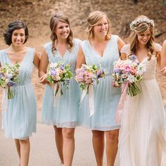 a group of women standing next to each other holding bouquets