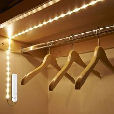 three wooden clothes hangers with lights on them