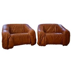 two brown leather chairs sitting next to each other