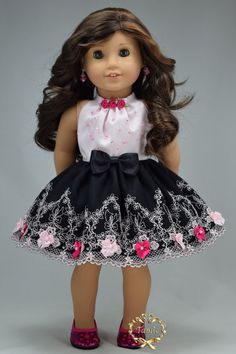 the doll is wearing a dress with pink flowers and black lace on it's skirt