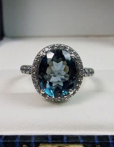 an oval shaped blue topaz ring in a box