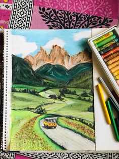 a drawing with colored pencils and crayons on the table next to it