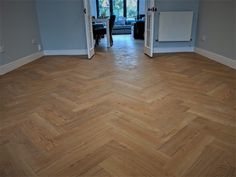 an empty room with hard wood flooring and blue walls in the background is a living area