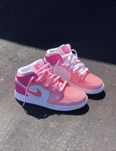 a pair of pink and white shoes on the ground