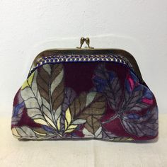 The Noor pouch with its old-fashioned clasp, "kiss lock", which gives it a unique and original style. You can take it for your evenings and go out light. The fabric is a cotton velvet printed with foliage that you can marry with different clothing styles. Finish with a navy blue and gold braid. The purple indigo lining has been handcrafted and is made of 100% cotton. The height is 14 cm The width is 20 cm. The width of the clasp is 17 cm The width of the opening is 7 cm. The Noor little purse, w Elegant Rectangular Coin Purse With Fold Over Clasp, Evening Coin Purse Clutch With Zipper, Formal Rectangular Coin Purse With Zipper, Formal Rectangular Zipper Coin Purse, Rectangular Zipper Coin Purse For Evening, Evening Rectangular Coin Purse With Zipper, Rectangular Evening Coin Purse With Zipper, Elegant Evening Coin Purse With Zipper, Handmade Formal Clutch Coin Purse