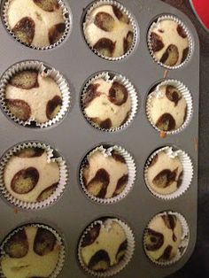 cupcakes with white frosting sitting in a muffin tin