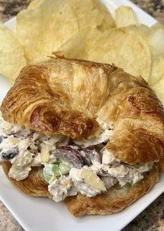 a croissant sandwich with chicken salad and chips