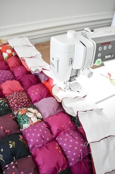 a sewing machine sitting on top of a pile of pillows