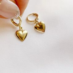 14k gold filled hearts dangle from huggie style hoops. Lightweight. Size: approx 1” 14k gold filled hoops Charms: 10mm Lever back closure Lead & nickel free / Hypoallergenic Handmade Includes 100% organic cotton jewelry pouch This item is made to order, packaged, and shipped with love from our studio located in West Chester, PA. *Click here to learn more about gold filled jewelry Gold Plated Huggie Jewelry For Gifts, Dainty Heart-shaped Tarnish-resistant Huggie Earrings, Small Hoop Tarnish-resistant Jewelry For Valentine's Day, Small Hoop Tarnish Resistant Jewelry For Valentine's Day, Valentine's Day Tarnish-resistant Small Hoop Jewelry, Dainty Tarnish-resistant Huggie Heart Earrings, Sterling Silver Heart Earrings Tarnish Resistant For Everyday, Dainty Gold Plated Nickel Free Huggie Earrings, Minimalist Hoop Jewelry With Heart Charm