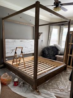 a wooden bed frame being constructed in a room with white paint on the walls and floor