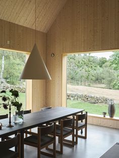 a dining room with large windows and wooden walls