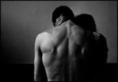 a man and woman embracing each other in black and white, with their backs to the camera