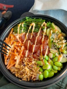 a black bowl filled with lots of different types of food on top of a table