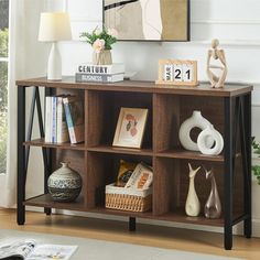 a wooden shelf with books and vases on it in a room next to a window