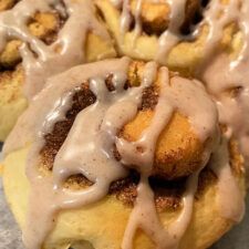 cinnamon rolls covered in icing and drizzled with chocolate