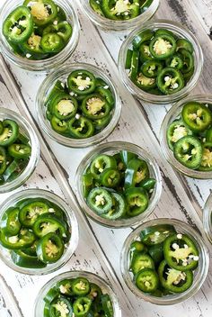 green peppers are in small glass bowls on a white wooden table, ready to be cooked