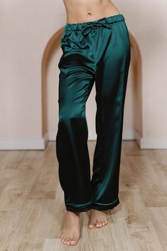 a woman in blue pajama pants is standing on the floor with her hands behind her head