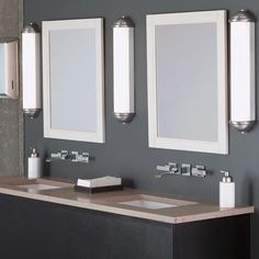 a bathroom vanity with three mirrors and two lights on the wall next to each other