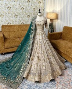 a mannequin dressed in a white and green lehenga with matching dupatta